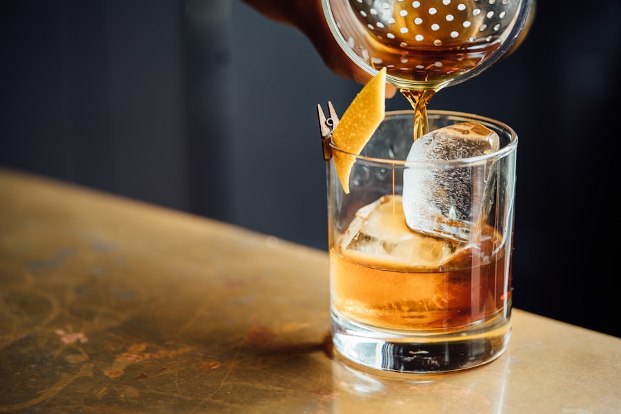 A cocktail being poured over ice at a bar